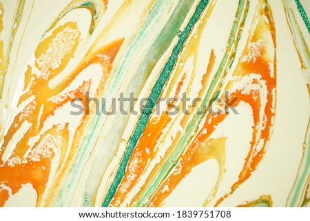 This marble-like pattern has a peachy orange tone and has a pearly green tint. The background image is yellowish white.