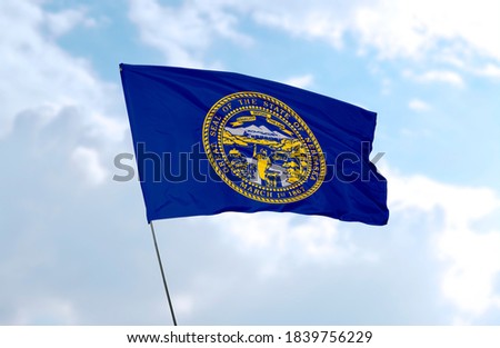Flag of Nebraska in front of blue sky