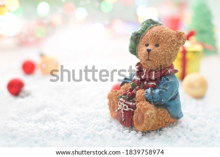 Christmas background with teddy bear on white now and present box. Beautiful cute winter scene.