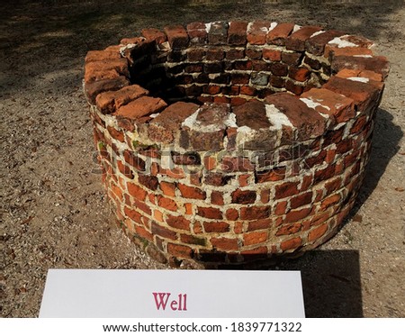red brick well with sign or label