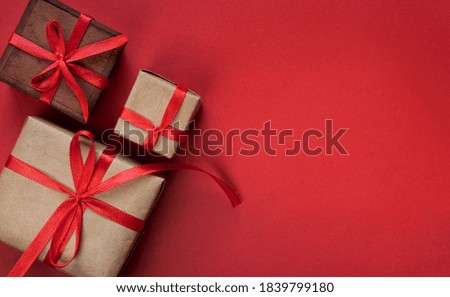 Gift boxes tied with red ribbons on red background, christmas decoration, presents packing 