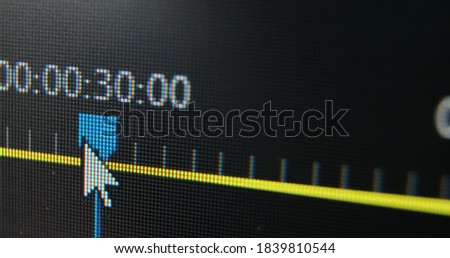 Blue slider moves along yellow timeline while film editor works with video sequence in computer program macro view