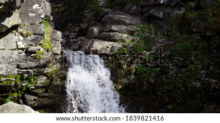 Beautiful waterfall in the mountains among the rocks