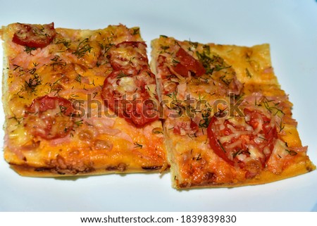 Homemade pizza cut into a square with ham and cheese
