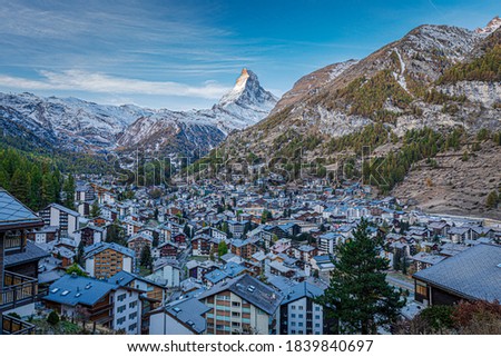 The Swiss village of Zermatt in Valais in autumn at sunrise, with the Matterhorn and the Alpine mountain range in the background.