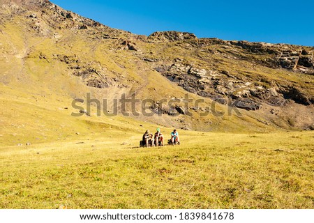Group of trekkers resting in high mountains. Young men and women hiking near Sary Chelek lake, Sary-Chelek Jalal Abad region, Kyrgyzstan, Trekking in Central Asia.