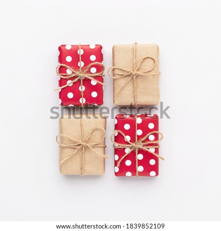 Christmas gifts composition. New year flatly with red dotted and craft gifts with bows at grey background. Xmas concept.