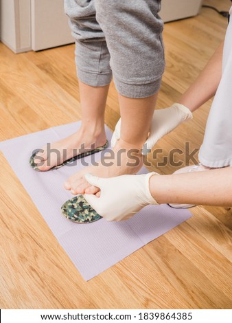 Patient at the podiatrist examination room trying silicone insoles on his feet, no faces shown Royalty-Free Stock Photo #1839864385