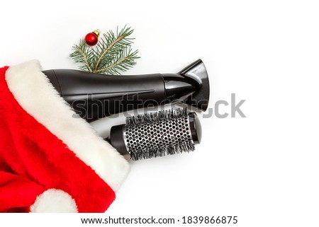 Christmas composition. Hairdressing tools and a spruce branch on a white background, hair dryer, comb. Template for a postcard or information about a hair salon. Flat lay, copy space