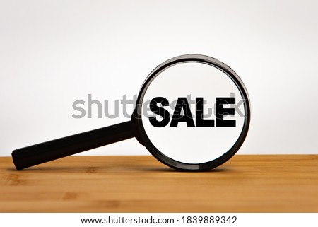 Focused on business concept. Magnifier glass with word sale on wooden table. Business concept. Search idea