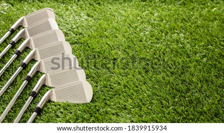 Golf clubs set on green course lawn close up view. Golfing sport and equipment concept, copy space, template.