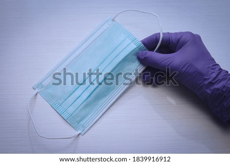 Hand with gloves and disposable mask