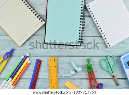 Flatlay view of school and office stationary isolated on a green background. Calculator, scissors, geometry compass and other tools. Education and business concept. Copy space for text