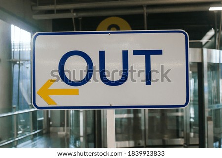 Blue "OUT" letters in banner on a white stick