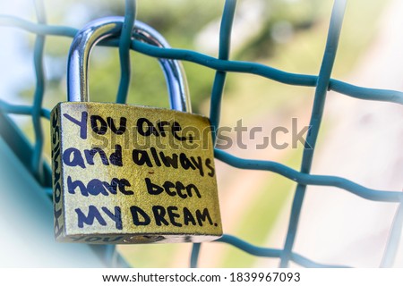 Gold love lock on frence that says Promise and You are and always have been my dream with bokeh background