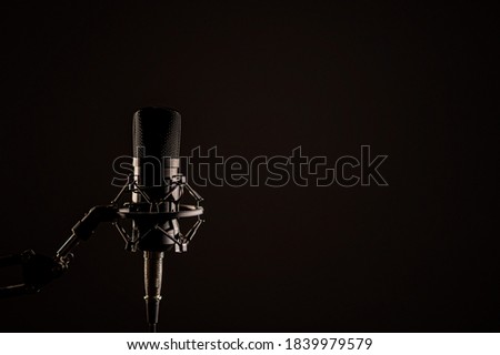 Close-up of a professional microphone for a radio broadcast on a black background. Recording studio equipment