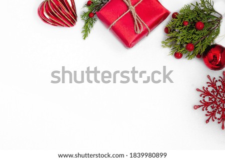 green branch with red balls, red gift, Christmas tree toy and shiny snowflake Royalty-Free Stock Photo #1839980899