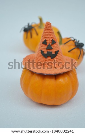 Halloween pumpkins with witch hat on a white glitter background. Creative concept.
