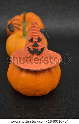 Halloween pumpkins with witch hat on a black glitter background. Creative concept.