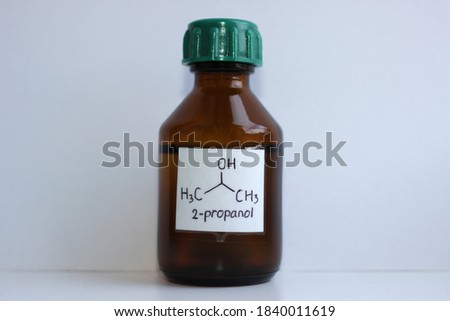 Isopropyl alcohol in a dark glass jar with the formula, the substance is widely used in chemistry, as a solvent in the paint and varnish, pharmaceutical industries. Royalty-Free Stock Photo #1840011619