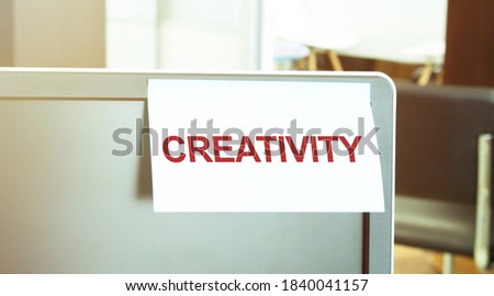 Sticky note on the computer. Text CRATIVITY