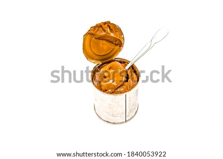 Boiled condensed milk in a tin can on a white background.