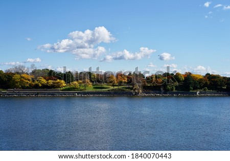 View of a green island in the middle of a river covered with autumn trees, Montreal, Quebec, Canada