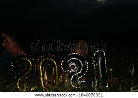 Young girl with the number 2021 on a dark background. happy New Year