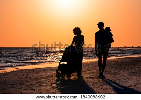 Sunset in Siesta Key, Florida near Sarasota, USA with coastline coast ocean gulf of mexico, young couple silhouette walking on beach shore