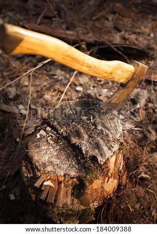 Closeup photo of iron axe stuck in wood log