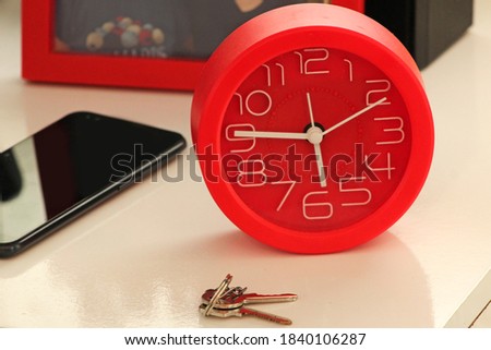 red clock on the counter with a key
