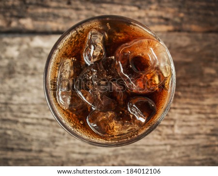 Cola in glass with ice from top view on table. Royalty-Free Stock Photo #184012106