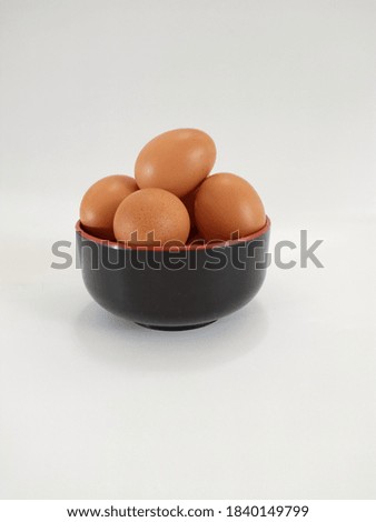 The picture of raw chicken egg in a black bowl with high key or bright mood photography. This picture is taken in Jakarta-Indonesia, on Sunday, 25 of October 2020.