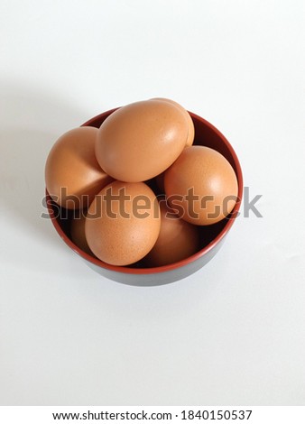 The picture of raw chicken egg in a black bowl on a table with high key or bright mood photography. This picture is taken in Jakarta-Indonesia, on Sunday, 25 of October 2020.