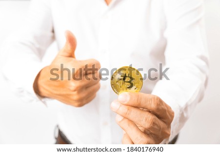Golden Bitcoin in a business man hand, Digital symbol of a new virtual currency.