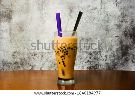 A picture of spicy milk boba tea instant noodle on table and crack wall. A new trending food in Malaysia.