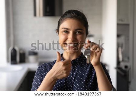 Close up headshot portrait of smiling young Indian woman show keys buy first own house. Profile picture of excited ethnic female renter tenant show thumb up recommend real estate agency good service. Royalty-Free Stock Photo #1840197367