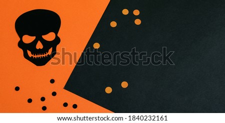 Halloween black-orange background with decorative scull and peas. 