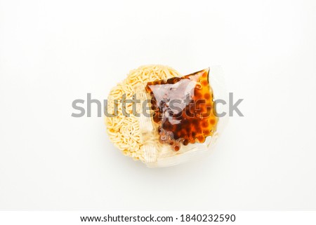 Flatlay picture of round instant noodle with tapioca ball on white background. New and trending food instant noodle serve in spicy pearl milk or boba tea.