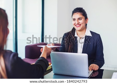 Indian woman working in a bank as a relationship manager issuing loan approval to the customer Royalty-Free Stock Photo #1840242793