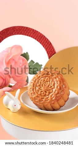 Mooncake on Light Pink Background with Pink Flower. Concept Moon Cake on Mid Autumn Festival. Mooncake Popular as Kue Bulan.