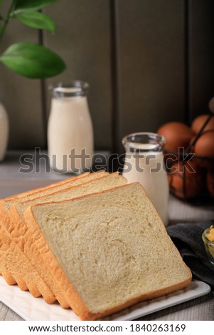Sliced Toast Loaf White Bread (Shokupan or Roti Tawar) for Breakfast on Wooden Background, Served with Egg and Milk. Bakery Concept Picture