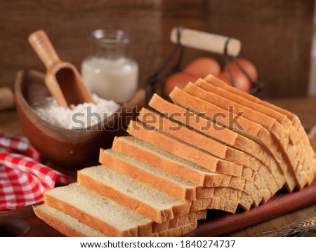 Sliced Toast Loaf White Bread (Shokupan or Roti Tawar) for Breakfast on Wooden Background, Served with Egg and Milk. Bakery Concept Picture