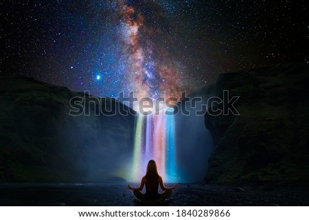 Woman doing yoga in front of a magic waterfall Royalty-Free Stock Photo #1840289866