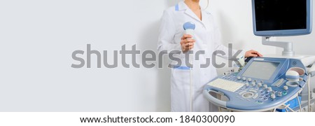 Close up doctor hand  holding an ultrasound transducer. Ultrasound pregancy examination. Copy space for you text Royalty-Free Stock Photo #1840300090
