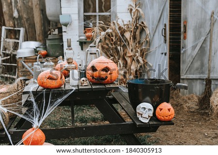 a barn decorated for Halloween with carved pumpkins and cobwebs