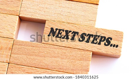 NEXT STEP word written on wood block. step text on table, concept