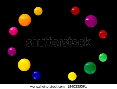 background frame made of colored magnetic paper clips on black background with space for text