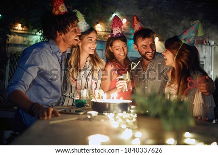 The birthday celebrant enjoying with friends at open air party on a beautiful summer night. Quality friendship time together