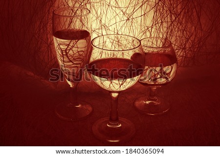 Three wine glasses with liquid on an abstract background. Close up, contour light, stylish background. Beautiful picture for a poster. Art.